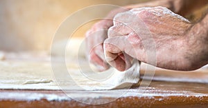 Male hands making dough on the table in the kitchen at home
