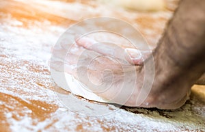 Male hands making dough on the table in the kitchen at home
