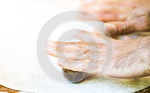 Male hands making dough on the table in the kitchen at home