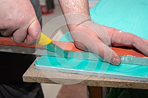 Male hands measure and cut drywall, sandwich panel with a construction knife. Repair of a house or apartment.
