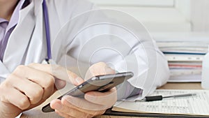 Male hands of medicalc doctor typing SMS message on smart phone.