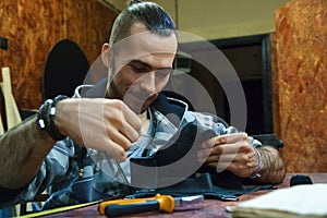 Male hands with needle and thread.