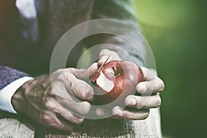 male hands peeling apple with knife