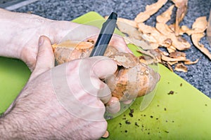 Male hands peeling sweet potatoes