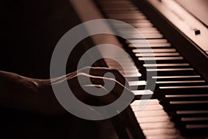 Male hands on the piano keys closeup of a beautiful colorful background