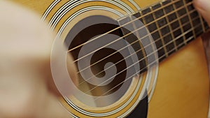 Male hands play an acoustic guitar solo. Close-up