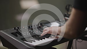 Male hands play synthesizer. Fingers press keys. Male musician, piano accompanist on black and white keyboards during