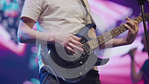 Male hands playing electric guitar close-up. Male musician with electric guitar in his hands