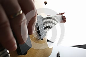 Male hands playing electric guitar on maple fretboard