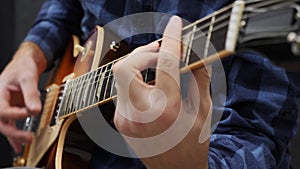 Male hands playing on guitar. Professional guitarist playing solo on electric guitar. Young man performing lyric song on music ins