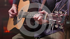 Male hands playing a song on an acoustic guitar