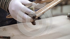 Male hands polishing cleaning wooden frame in woodcraft studio