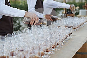Male hands pouring whiskey in glasses during fourchette
