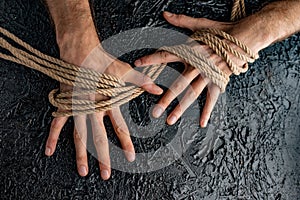 Male hands are pulling the rope on a black background