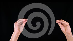 Male hands pulling and stretching something on black background. Hand gestures