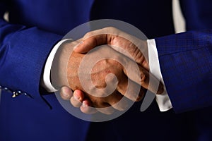 Male hands shaking tight. Handshake on light grey background