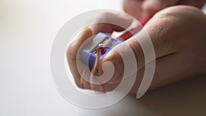 Male hands sharpen the red pencil.