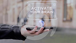 Male hands show on smartphone conceptual HUD hologram Activate your brain