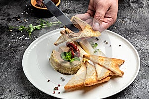 Male hands smear homemade paste on toasted bread. Fresh homemade pate. Liver pate. Delicious balanced food concept