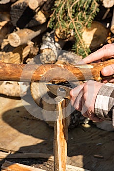 Male hands splitting wood with knife