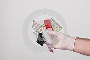 Male hands in surgical gloves hold packs of pills