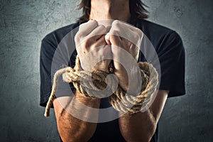 Male hands tied with a rope