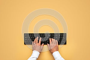 Male hands typing on black computer keyboard