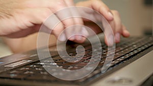 Male hands are typing on the keyboard of a computer or tablet.