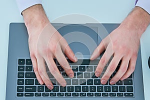 Male hands typing on laptop keyboard. Young man using laptop computer. Business working concept.