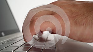 Male hands are typing text on a laptop keyboard on a white background.