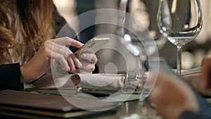 Male hands using mobile phone in cafe. Business couple using phone in restaurant