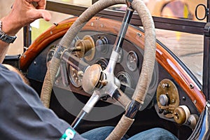 Male hands on vintage classic car steering wheel