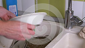 Male Hands Wash Dirty Plate in Kitchen Sink Under Running Water. Rinsing
