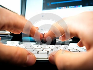 Male hands working on computer keyboard writing playing