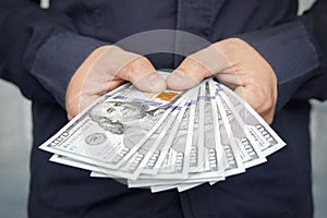 Male hands with wrist watch is considered American dollars. Hands holding dollar cash. 1000 dollars in 100 bills in a