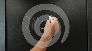 Male hands writing words Home Work with chalk on blackboard. Education concept