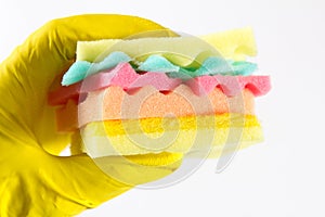 Male hands in yelliw gloves holding a burger made from sponges different colors. Concept of unhealthy food and non