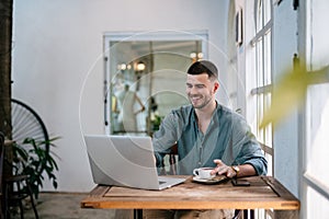 A male, Handsome Freelance man enjoying working on laptop at desk. freelance concept