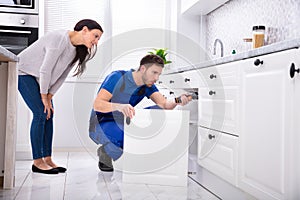 Male Handyman Installing Cabinet Door