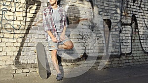 Male with headset standing near graffiti wall, listening to music, holidays