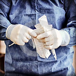 Male healthcare professional wearing protective gloves holds a large stack of syringes photo