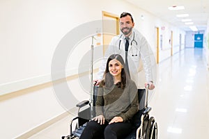 Male Healthcare Worker With Woman On Wheelchair At Hospital