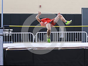 Male high jumper going over the bar indoors