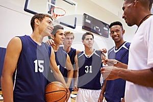 Male High School Basketball Team Having Team Talk With Coach