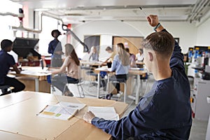 Male High School Student Asking Teacher Question In Design And Technology Lesson