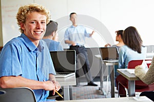 Male High School Student Using Laptop In Classroom