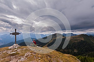 Male hiker with backpack relaxing on top of a mountain