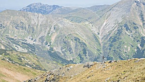 Mužský turista s batohem kráčí po hřebeni mezi velkými horami, EU, Slovensko