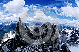 Male hiker celebrating at the top of the mountain