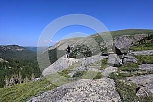 Male hiker enjoys expansive view of Indian Peaks Wilderness, Colorado.